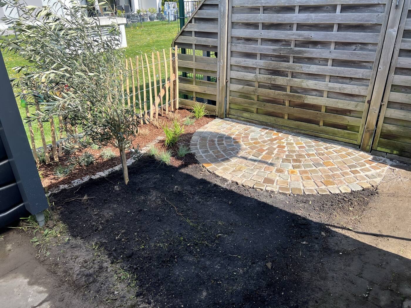 Runder Sitzplatz aus Kleinpflaster mit Olivenbaum